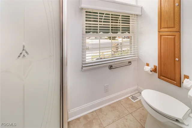 a bathroom with a window a sink and a toilet