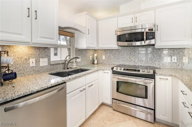 a kitchen with stainless steel appliances granite countertop a sink a microwave and cabinets
