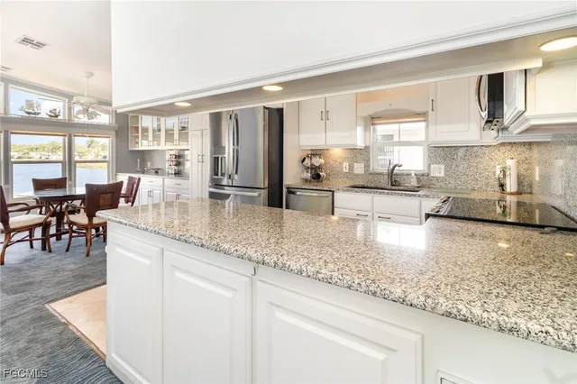 a kitchen with stainless steel appliances granite countertop lots of counter top space and furniture