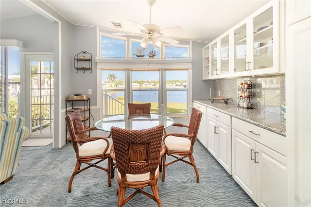 a dining room with wooden floor a chandelier a glass table and chairs