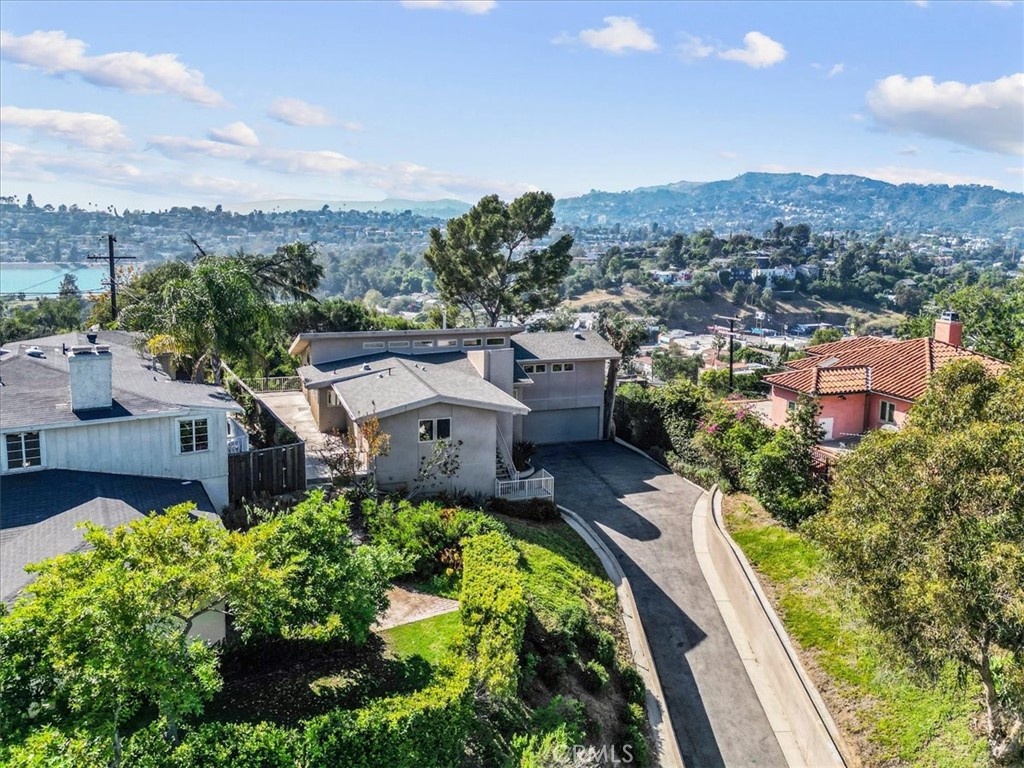 an aerial view of a house with a garden and mountains