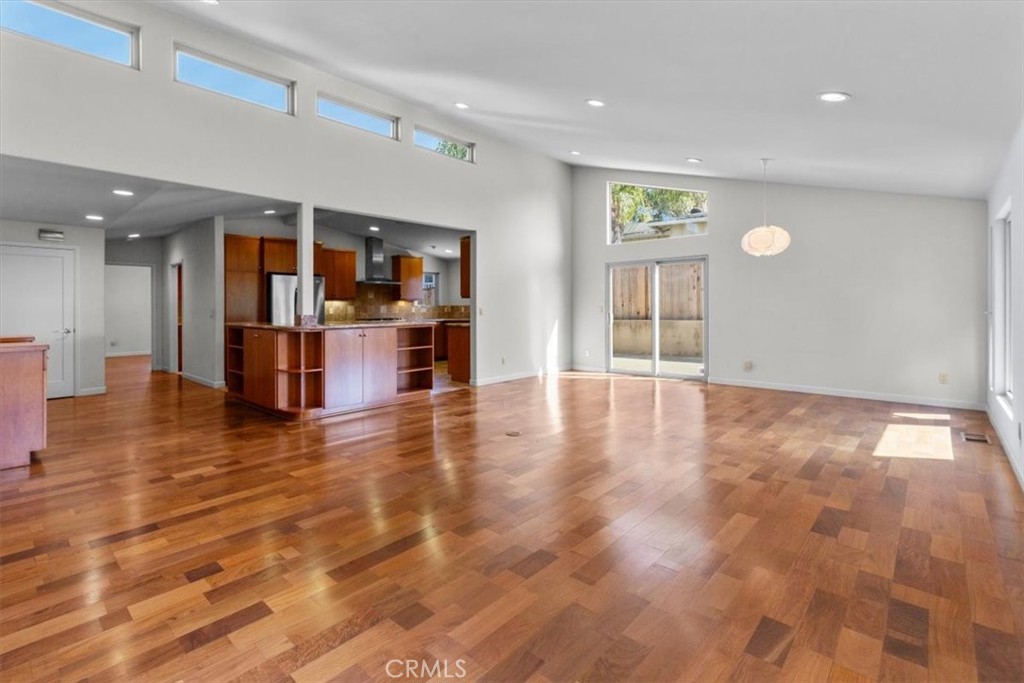 2377 Silver Ridge Avenue Los Angeles, CA 90039 - Photo 16 of 46 an empty room with wooden floor and entrance to kitchen