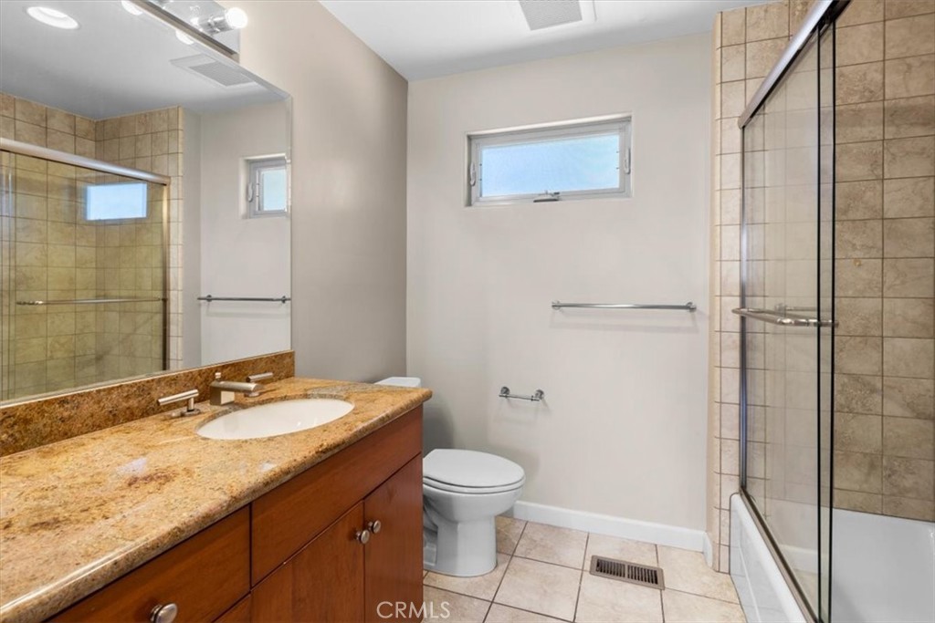 2377 Silver Ridge Avenue Los Angeles, CA 90039 - Photo 41 of 46 a bathroom with a granite countertop sink toilet a mirror and shower