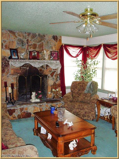 6415 Gaskins Road Jacksonville, FL 32244 - Photo 4 of 10 a living room with furniture and a chandelier