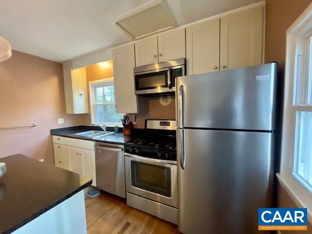 a kitchen with stainless steel appliances a refrigerator sink and microwave