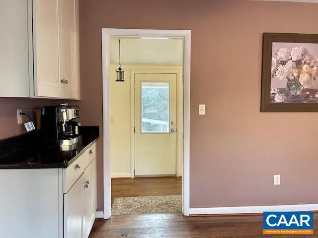 a kitchen with granite countertop white cabinets and black appliances
