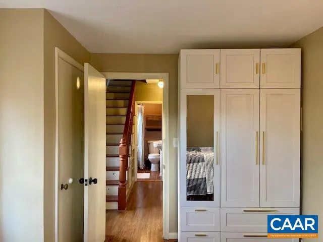 a view of a hallway with wooden floor and closet area