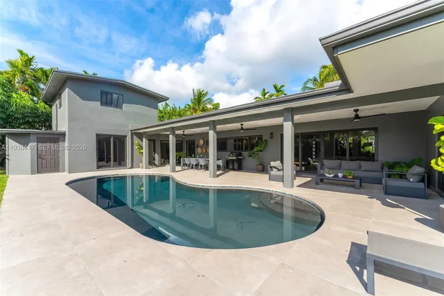 a living room with patio furniture and a floor to ceiling window