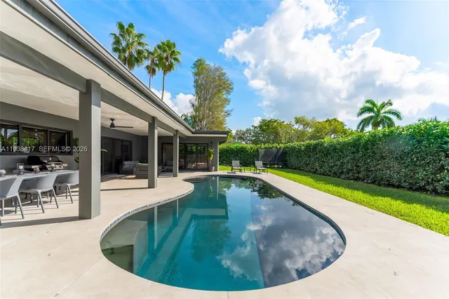 front view of a house with swimming pool and porch with furniture