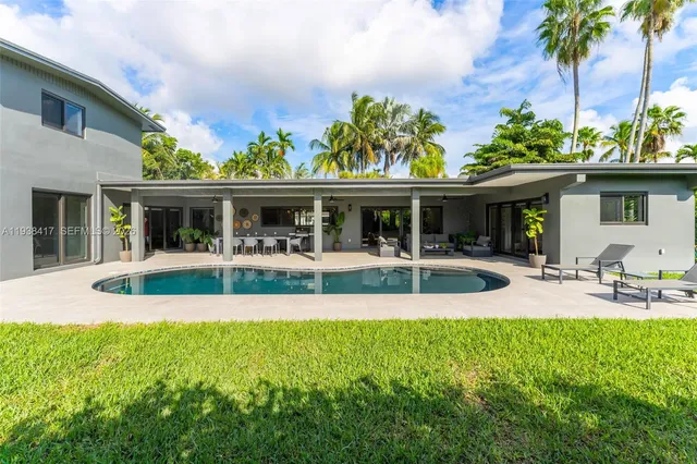 an aerial view of a city with lots of residential buildings ocean and mountain view in back