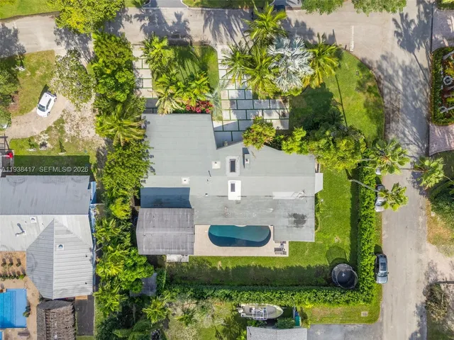an aerial view of residential houses with outdoor space and ocean view