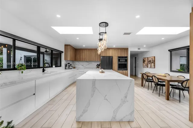 a kitchen with kitchen island a large counter top space appliances and cabinets
