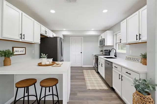 a kitchen with granite countertop a sink stove and cabinets