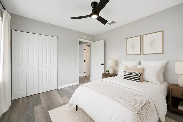 a bedroom with a bed and wooden floor