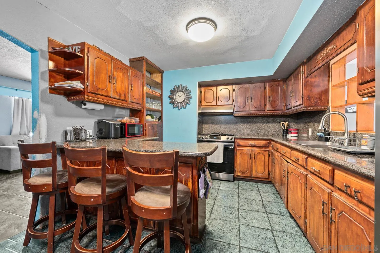 124 East View Street Fallbrook, CA 92028 - Photo 6 of 50 a kitchen with stainless steel appliances granite countertop wooden cabinets a dining table and chairs