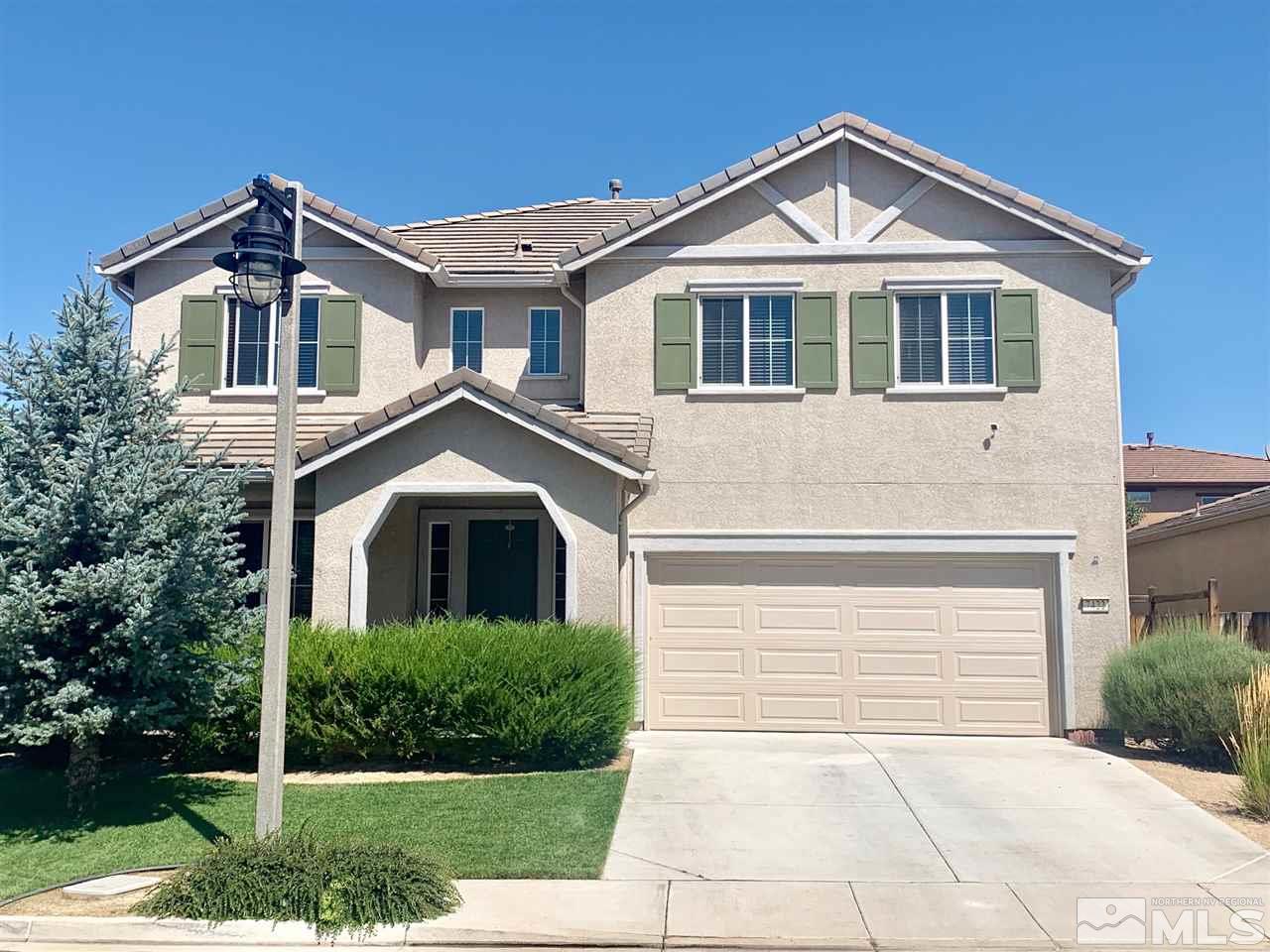 a front view of a house with a yard and trees