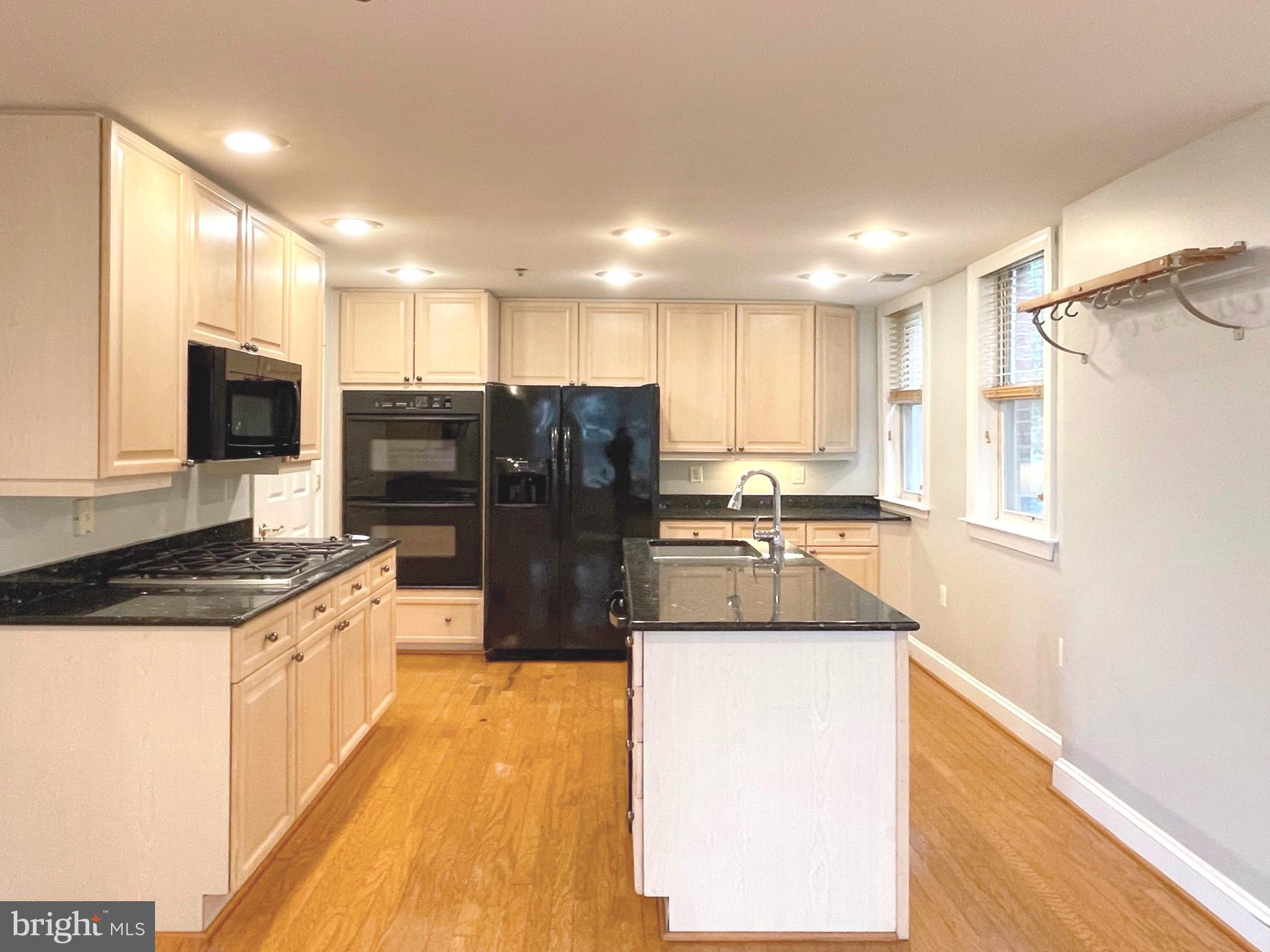 1555 North Colonial Terrace, Unit 600 Arlington, VA 22209 - Photo 11 of 29 a large kitchen with granite countertop a large counter top stainless steel appliances and cabinets