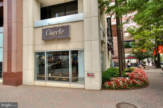 a group of people sitting in front of retail shop