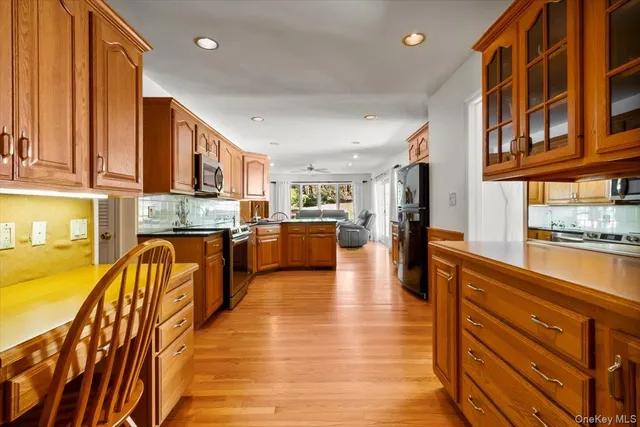 a kitchen with stainless steel appliances granite countertop a refrigerator a stove and a wooden floors