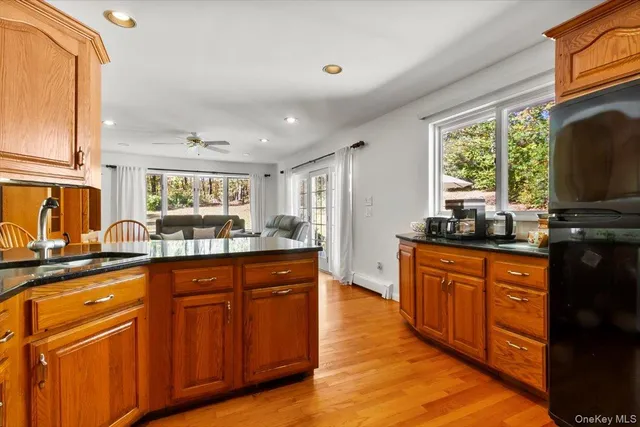 a kitchen with stainless steel appliances granite countertop wooden cabinets a sink and a large window