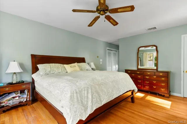 a bedroom with a bed and a dresser with potted plant