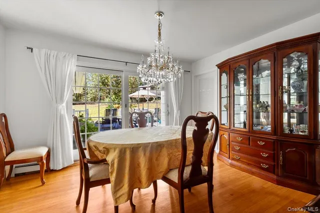a dining room with furniture a chandelier and wooden floor