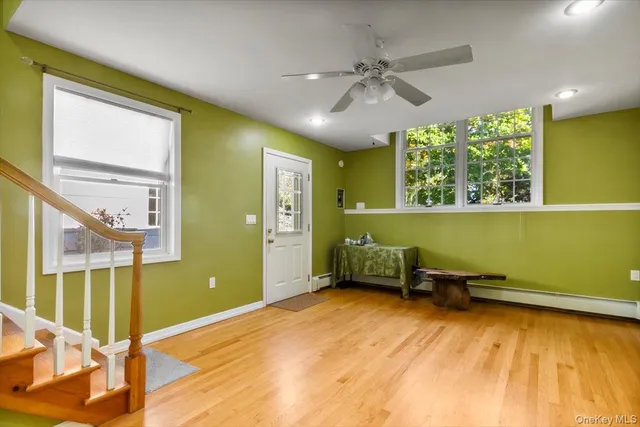 a view of a room with window a ceiling fan and wooden floor