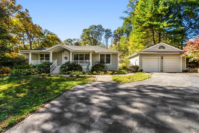 a front view of a house with a yard and trees