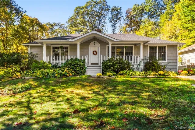 a front view of a house with a yard and a garden