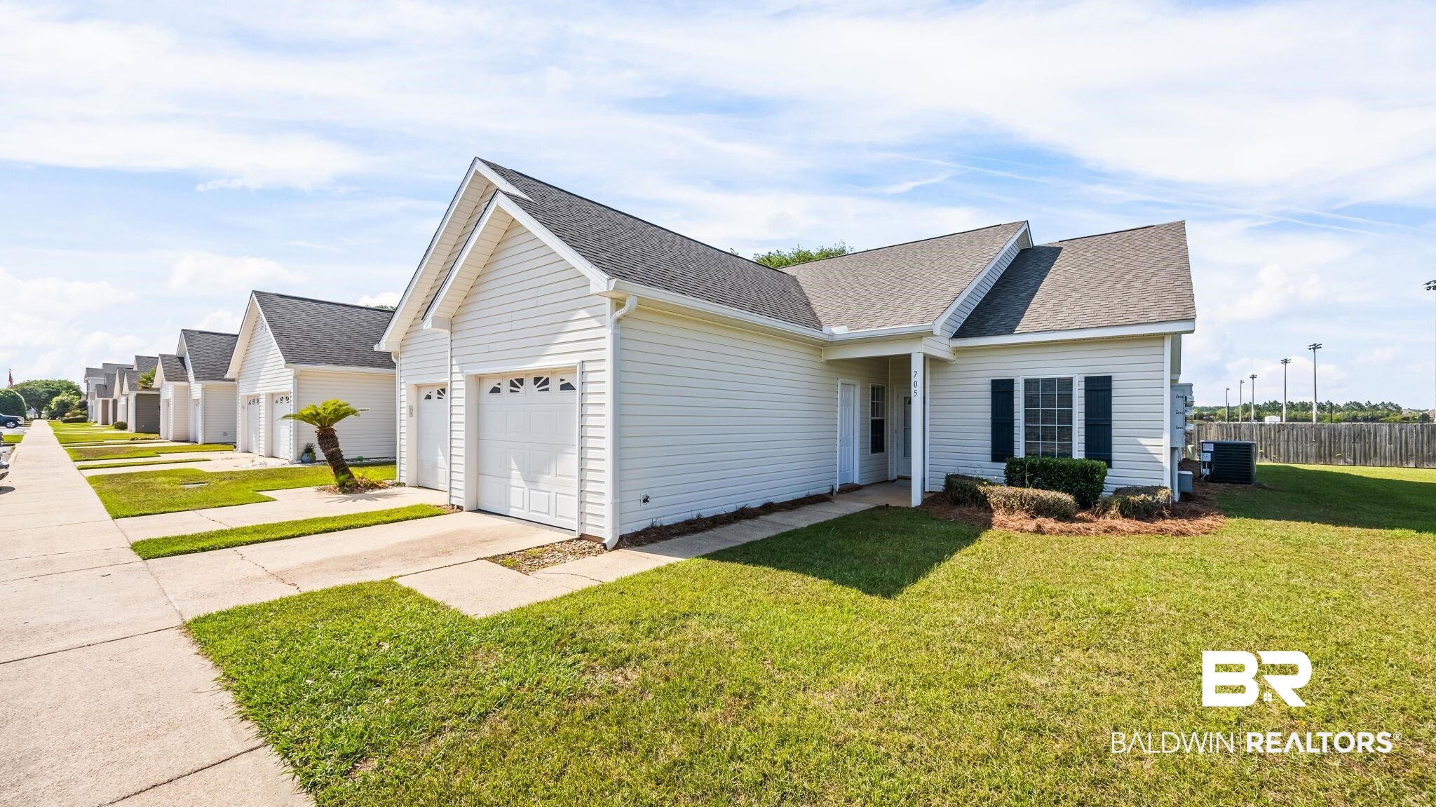 2651 South Juniper Street, Unit 705 Foley, AL 36535 - Photo 2 of 37 Single-story home featuring a covered entry, white siding, dark shutters, and a front lawn