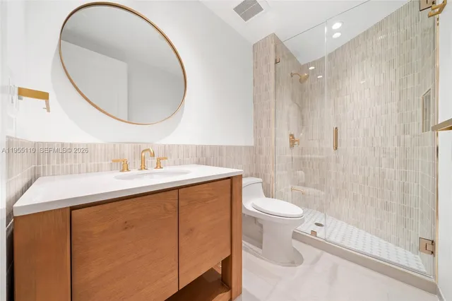 a bathroom with a sink a toilet and a mirror