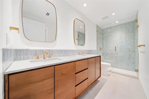 a bathroom with a double vanity sink mirror double and a shower