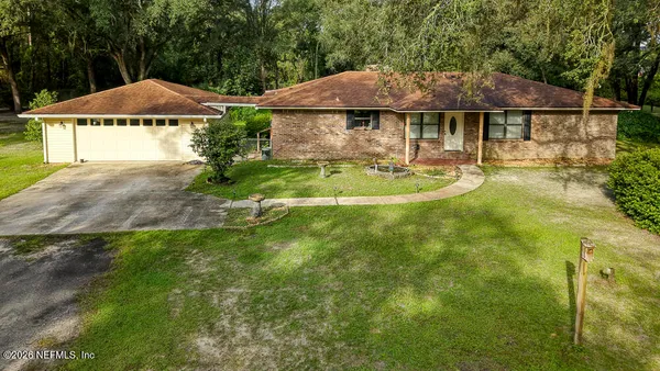 a front view of a house with a yard and trees