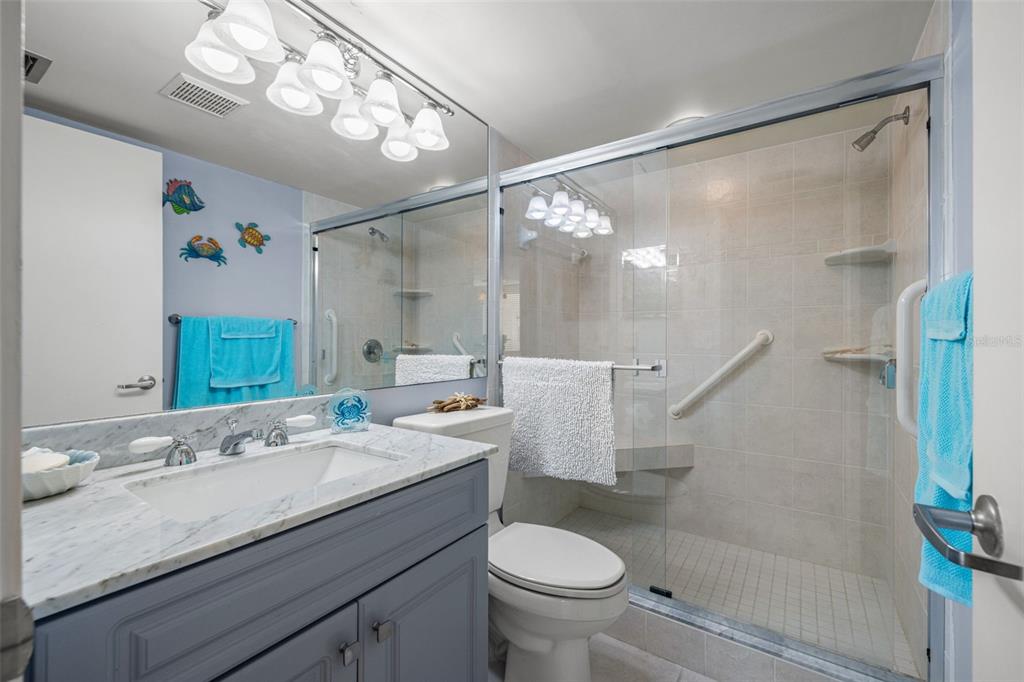 9495 Blind Pass Road, Unit 204 St. Pete Beach, FL 33706 - Photo 22 of 36 a bathroom with a sink a toilet and shower
