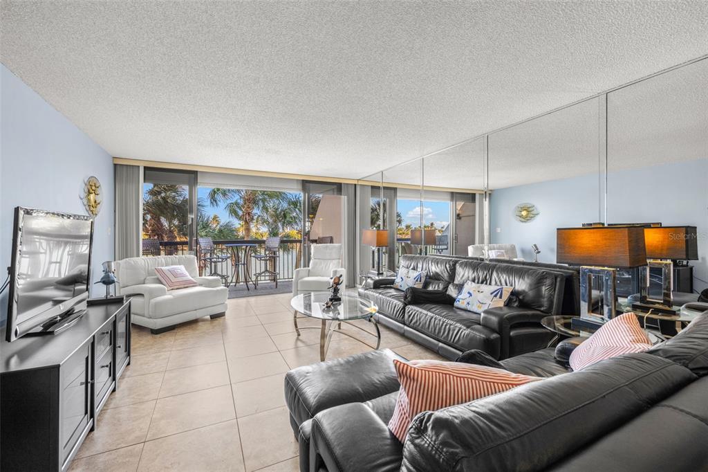 9495 Blind Pass Road, Unit 204 St. Pete Beach, FL 33706 - Photo 3 of 36 a living room with furniture and a flat screen tv