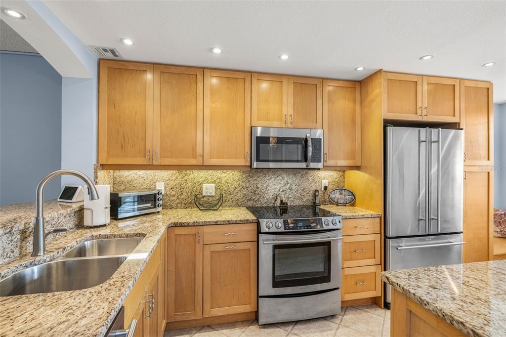 9495 Blind Pass Road, Unit 204 St. Pete Beach, FL 33706 - Photo 6 of 36 a kitchen with a sink stove and refrigerator