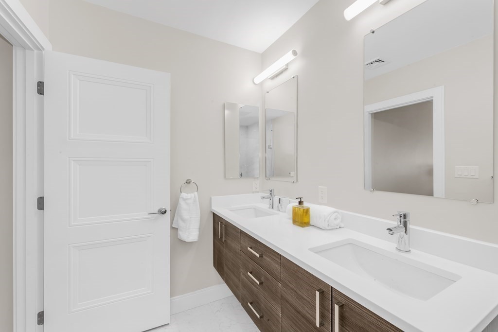 425 Lagrange Street, Unit 109 Boston, MA 02132 - Photo 19 of 42 a bathroom with a double vanity sink mirror and double