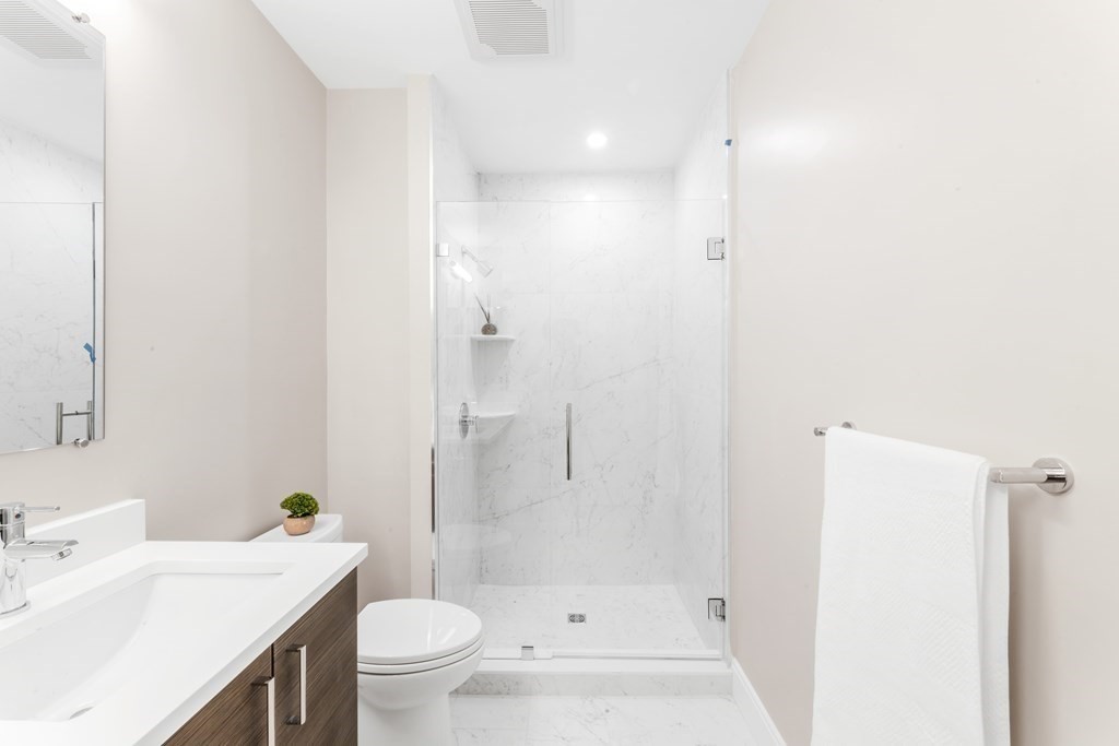 425 Lagrange Street, Unit 109 Boston, MA 02132 - Photo 20 of 42 a bathroom with a sink a toilet and shower
