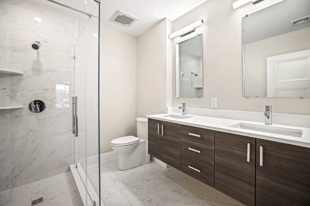 425 Lagrange Street, Unit 109 Boston, MA 02132 - Photo 25 of 42 a bathroom with a double vanity sink toilet and shower