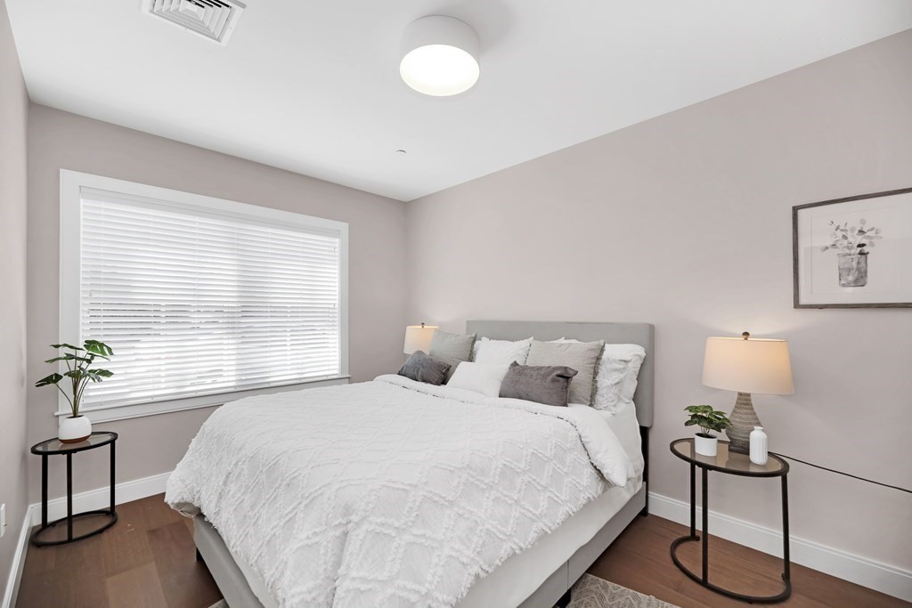 425 Lagrange Street, Unit 109 Boston, MA 02132 - Photo 30 of 42 a bedroom with a bed and a table lamp