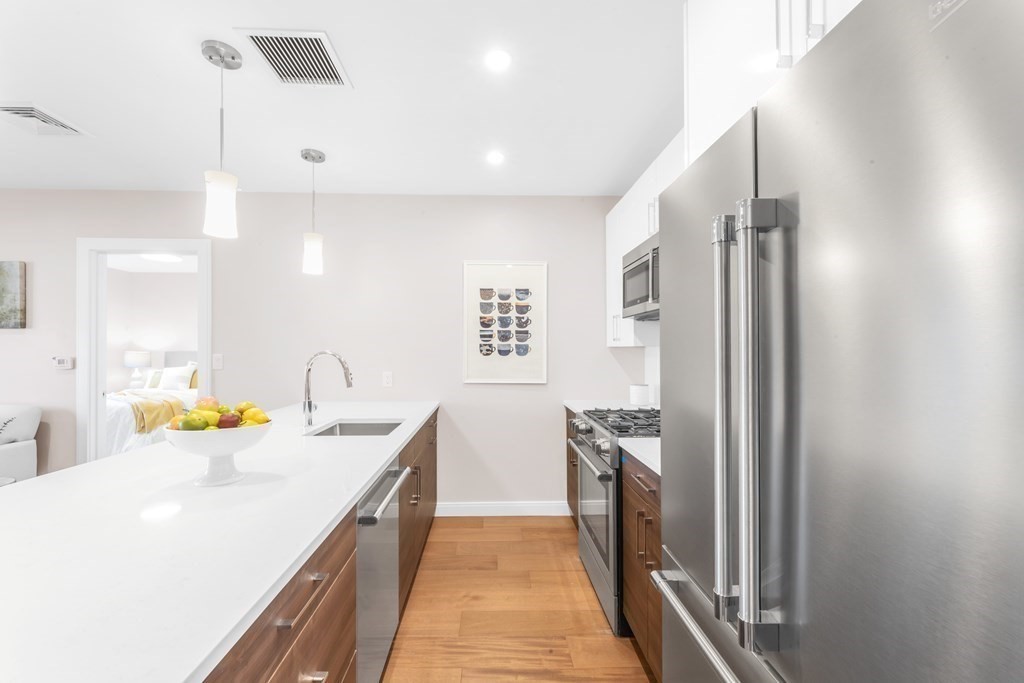425 Lagrange Street, Unit 109 Boston, MA 02132 - Photo 7 of 42 a kitchen with a sink appliances and cabinets