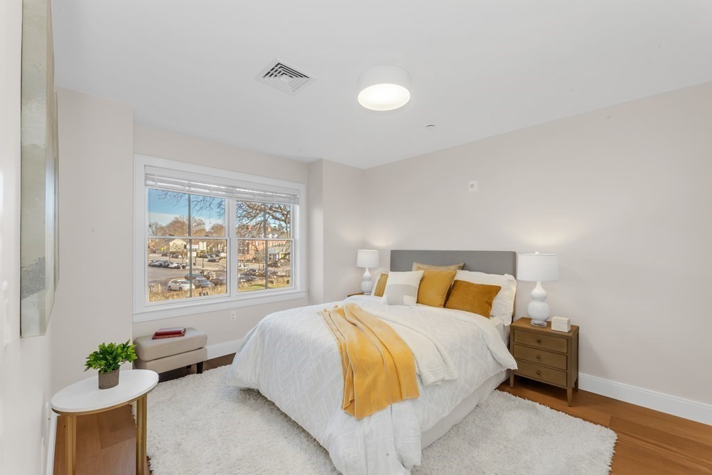 425 Lagrange Street, Unit 109 Boston, MA 02132 - Photo 9 of 42 a bedroom with a bed and a painting on the wall