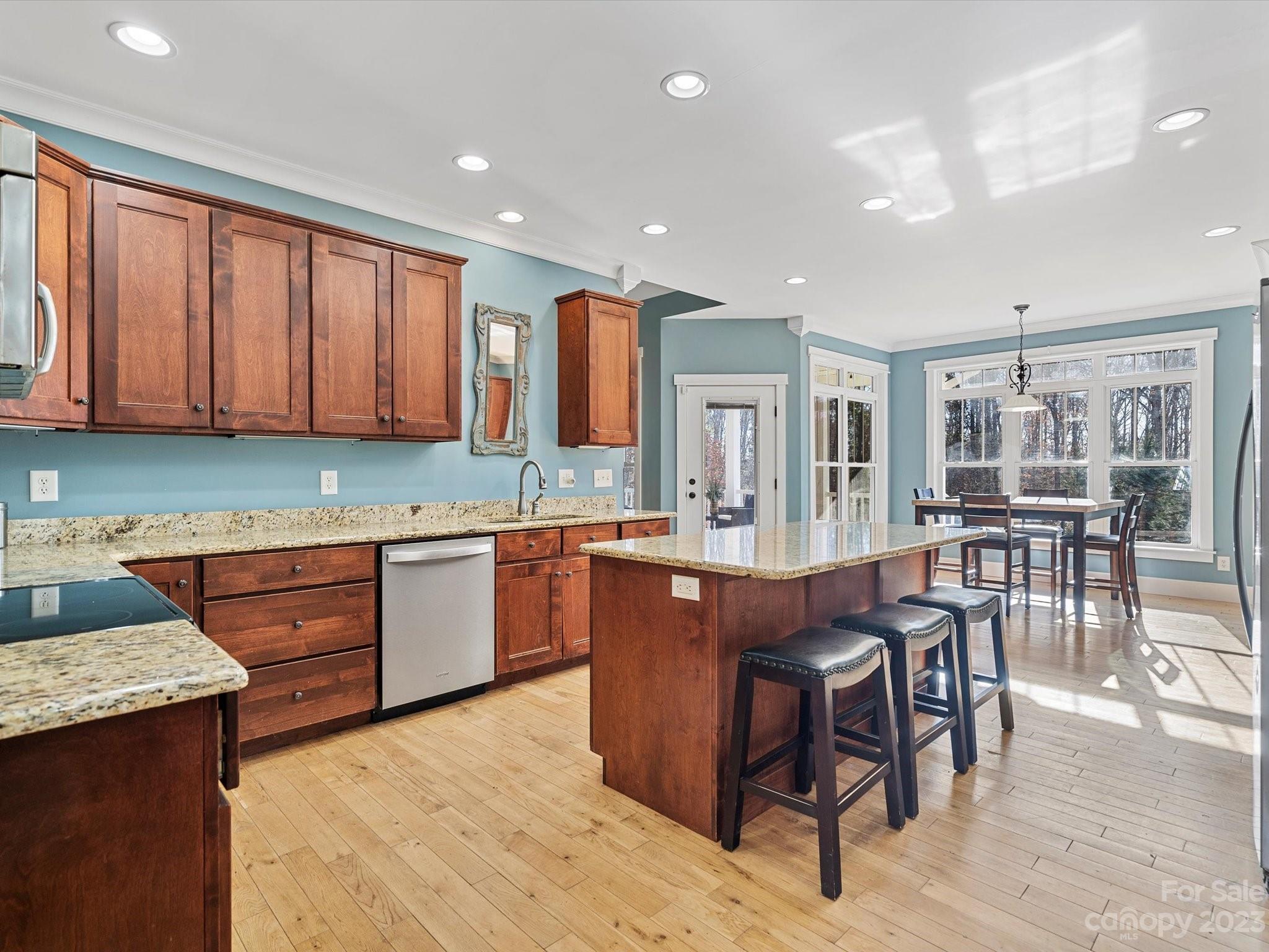 810 Sutton Spring Road York, SC 29745 - Photo 8 of 47 a large kitchen with stainless steel appliances granite countertop wooden cabinets a dining table and chairs