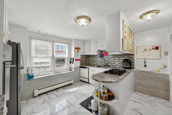 a kitchen with stainless steel appliances granite countertop a stove a sink and a refrigerator