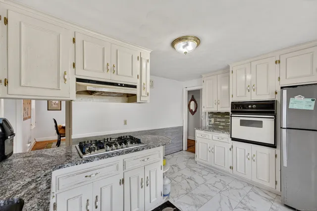 a kitchen with white cabinets and appliances