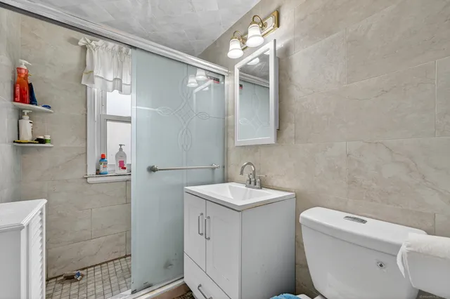 a bathroom with a sink a toilet and shower