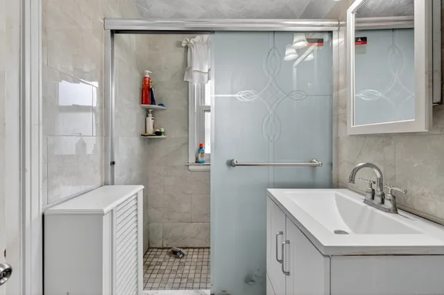 a bathroom with a shower sink and mirror