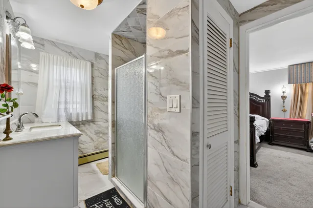 a bathroom with a granite countertop sink a mirror and a shower