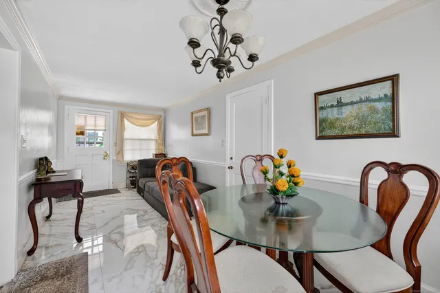 a view of a dining room with furniture and chandelier