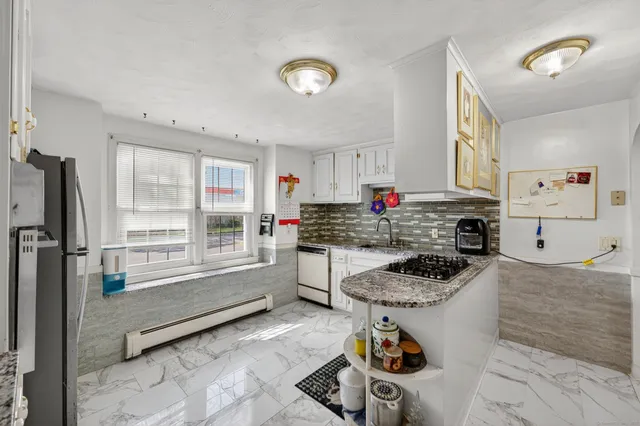 a kitchen with stainless steel appliances granite countertop a stove a sink and a refrigerator
